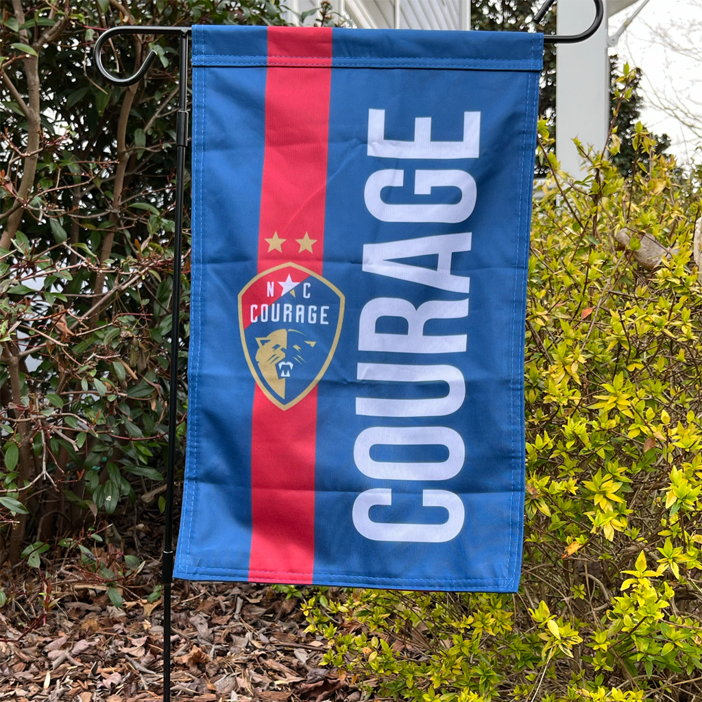 A double-sided garden flag with a blue and red striped background and the word 'COURAGE' in large letters. The flag also features a crest with a soccer ball and the letters 'NC Courage'.