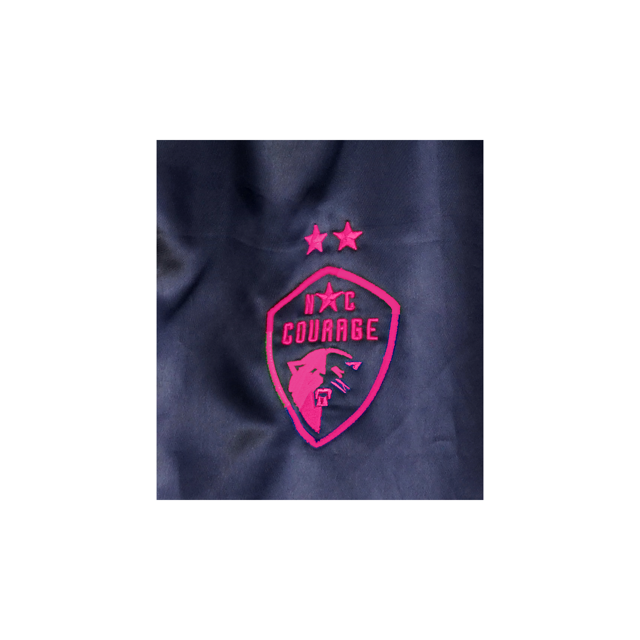 A close up of the hot pink Courage logo on the Black Satin jacket.