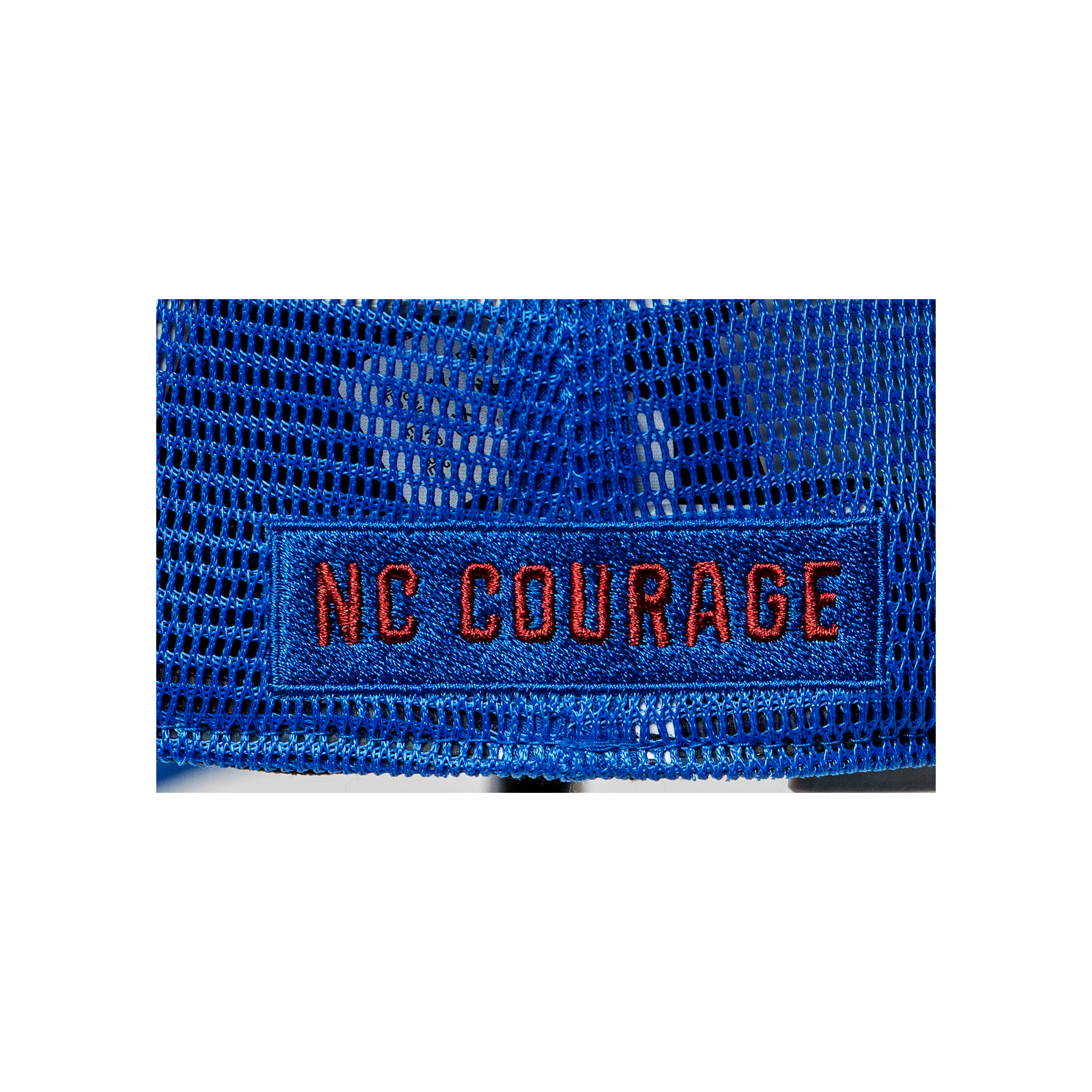 A close up of the NC Courage embroidered in red thread on a blue trucker hat.