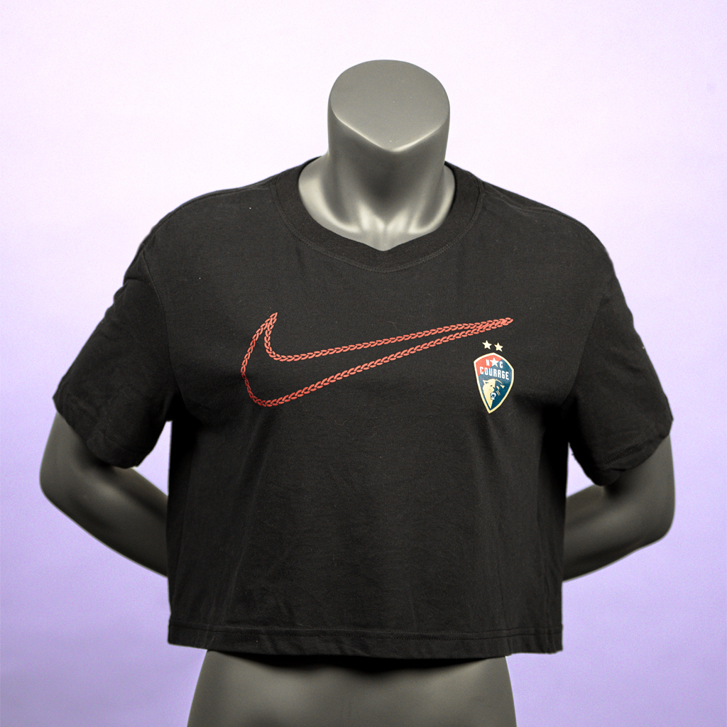 A black crop top featuring the Nike Swoosh logo in red and the NC Courage logo on the left chest area, displayed on a mannequin.
