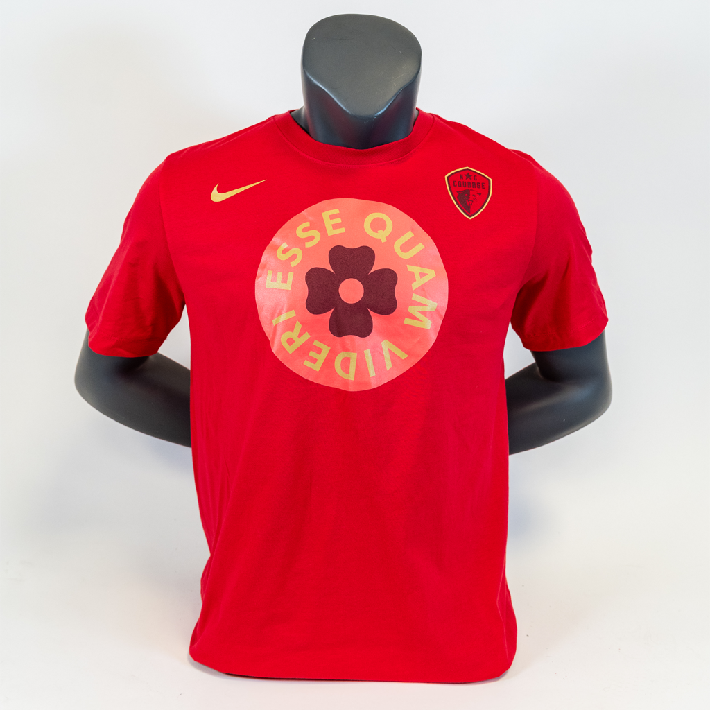 A pink Nike Dri-FIT t-shirt with a graphic design featuring a flower and the text 'ESSE QUAM VIDERI' displayed on the front, shirt featured on a mannequin.