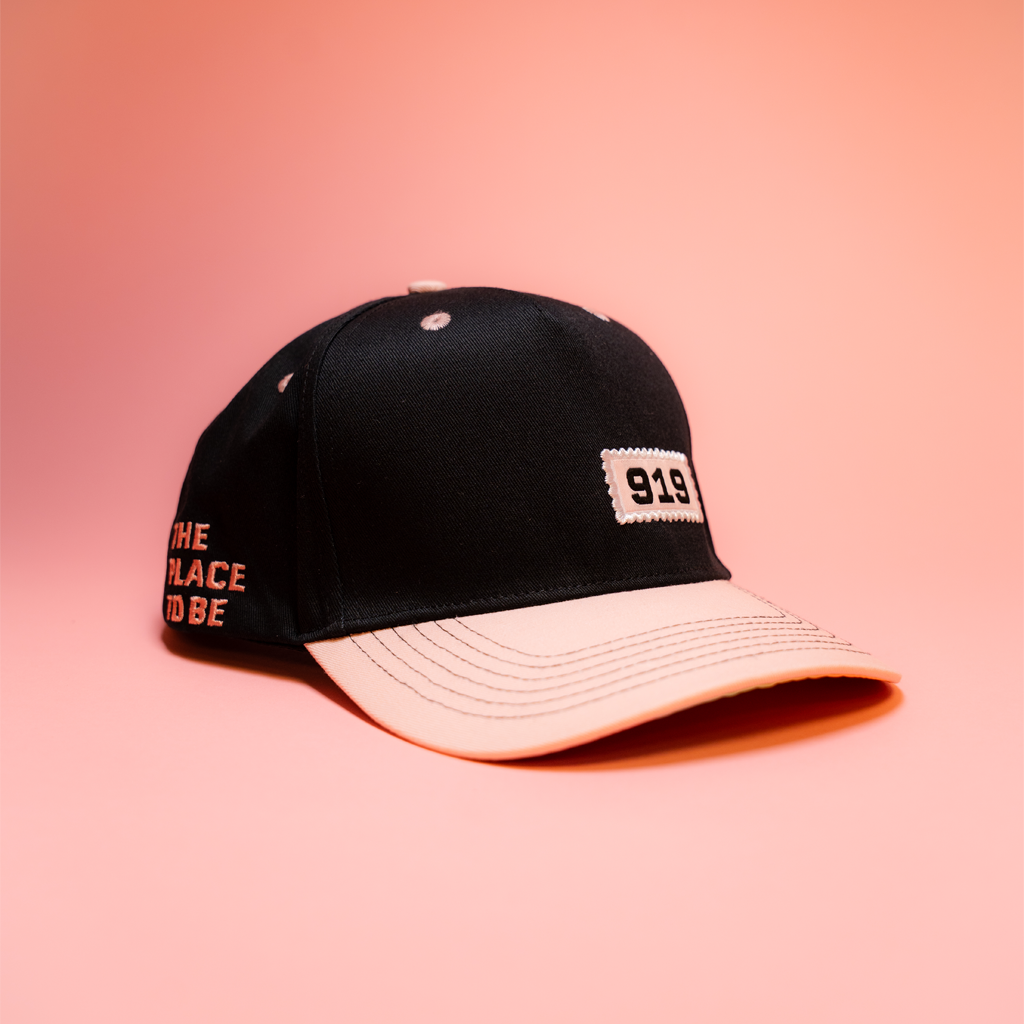 Black cap with text on a pink background