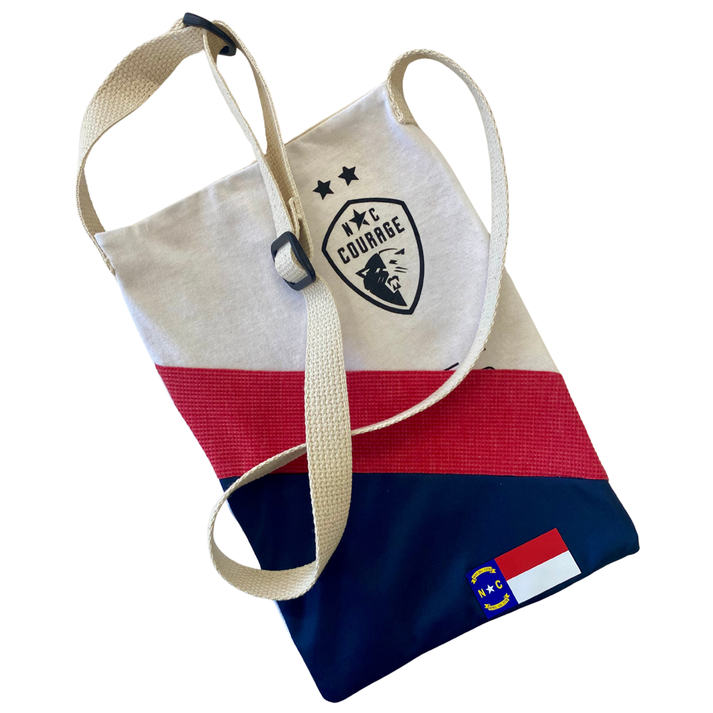 A Refried Crossbody Bag with a geometric pattern featuring red, blue, and white colors, along with the NC Courage logo.