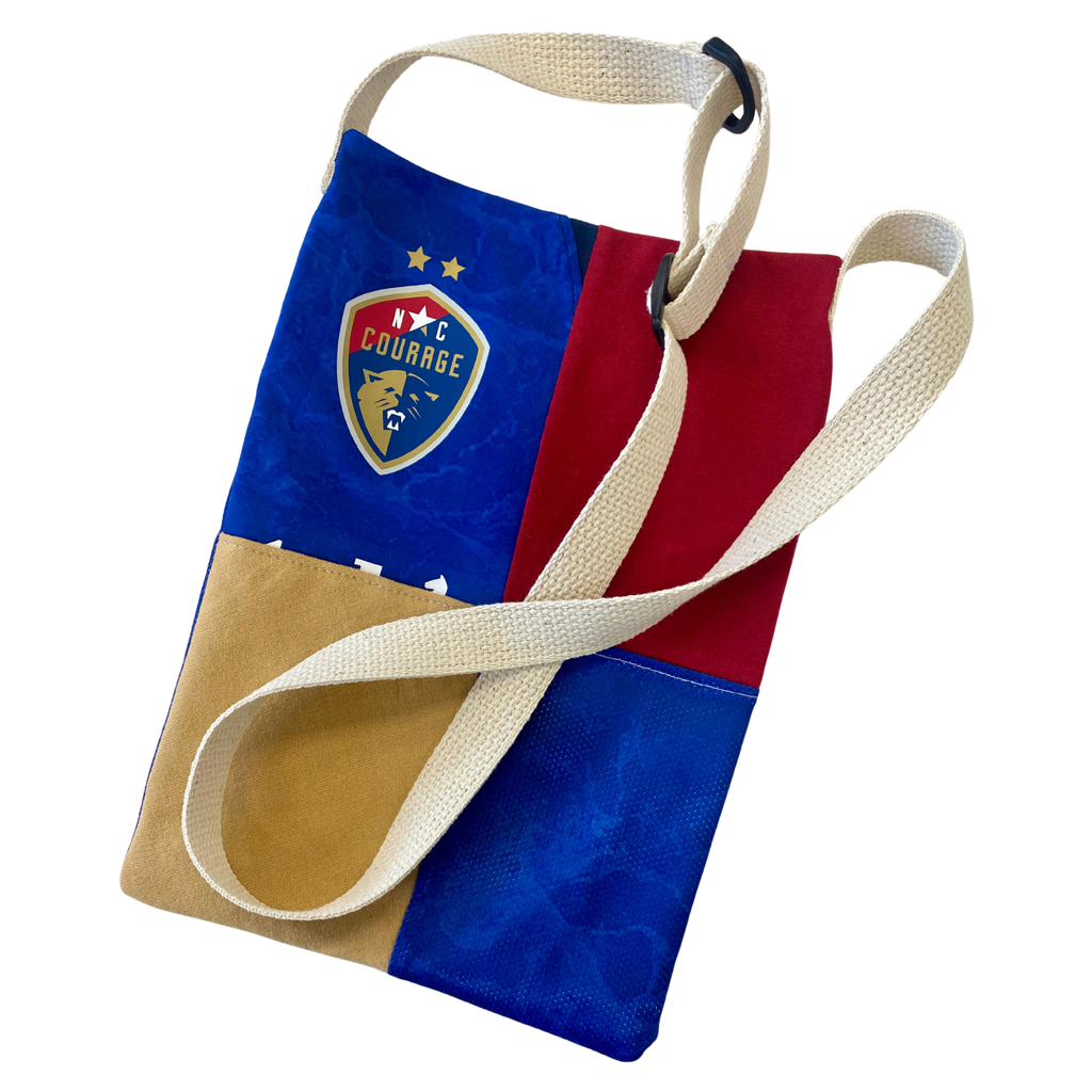 A Refried Crossbody Bag with a geometric pattern featuring red, blue, and white colors, along with the NC Courage logo.