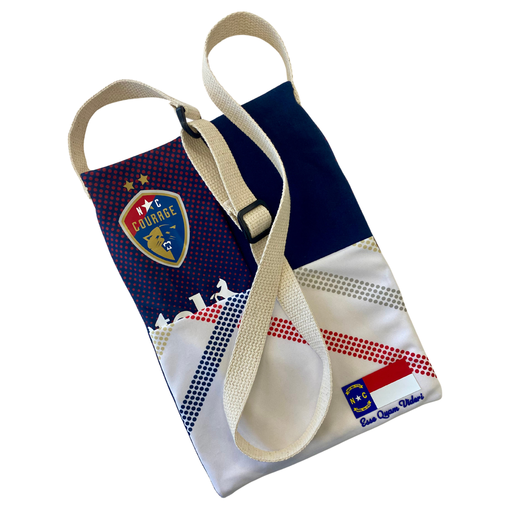 A Refried Crossbody Bag with a geometric pattern featuring red, blue, and white colors, along with the NC Courage logo.