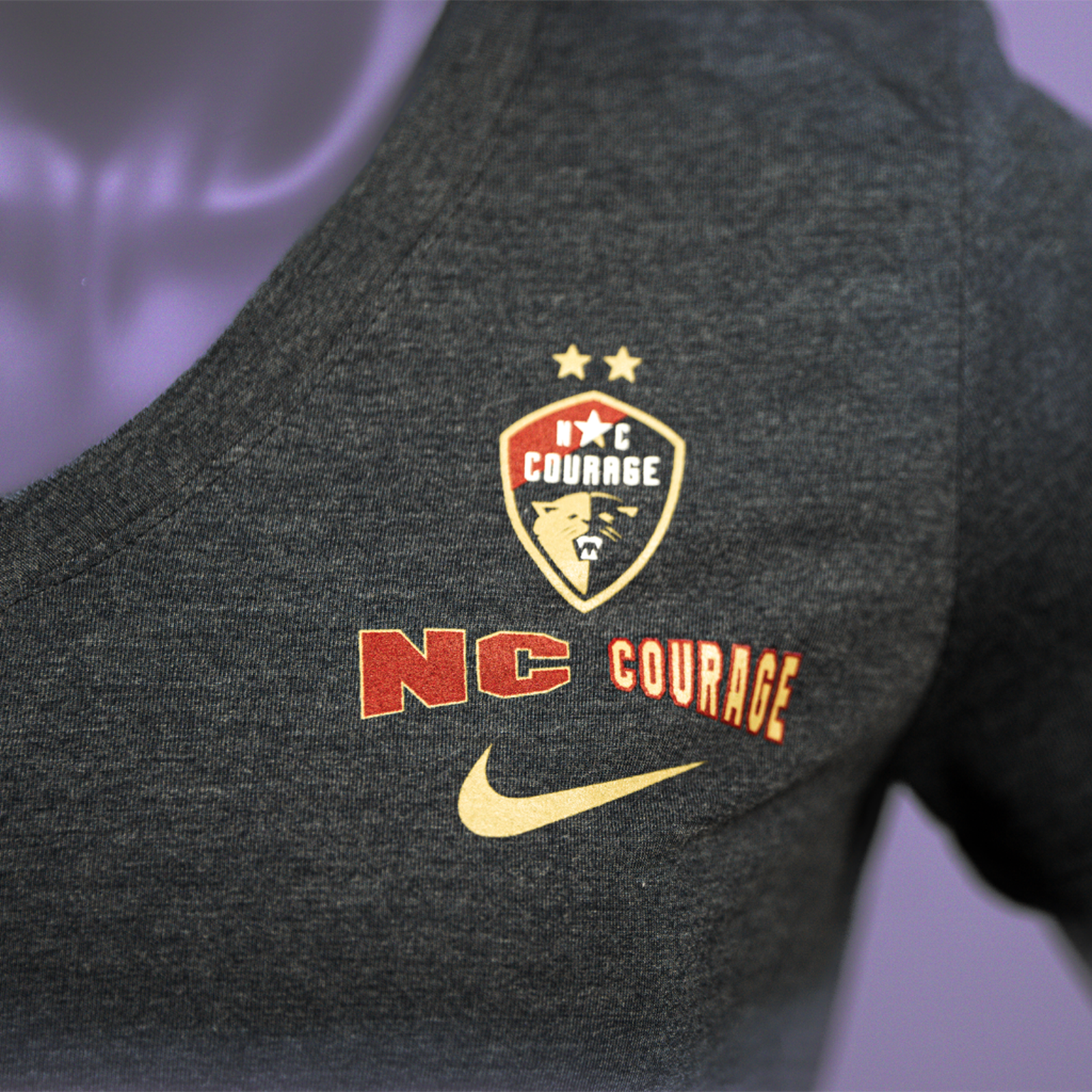 A close up of a navy triblend V-neck tee on a mannequin, featuring the NC Courage logo.