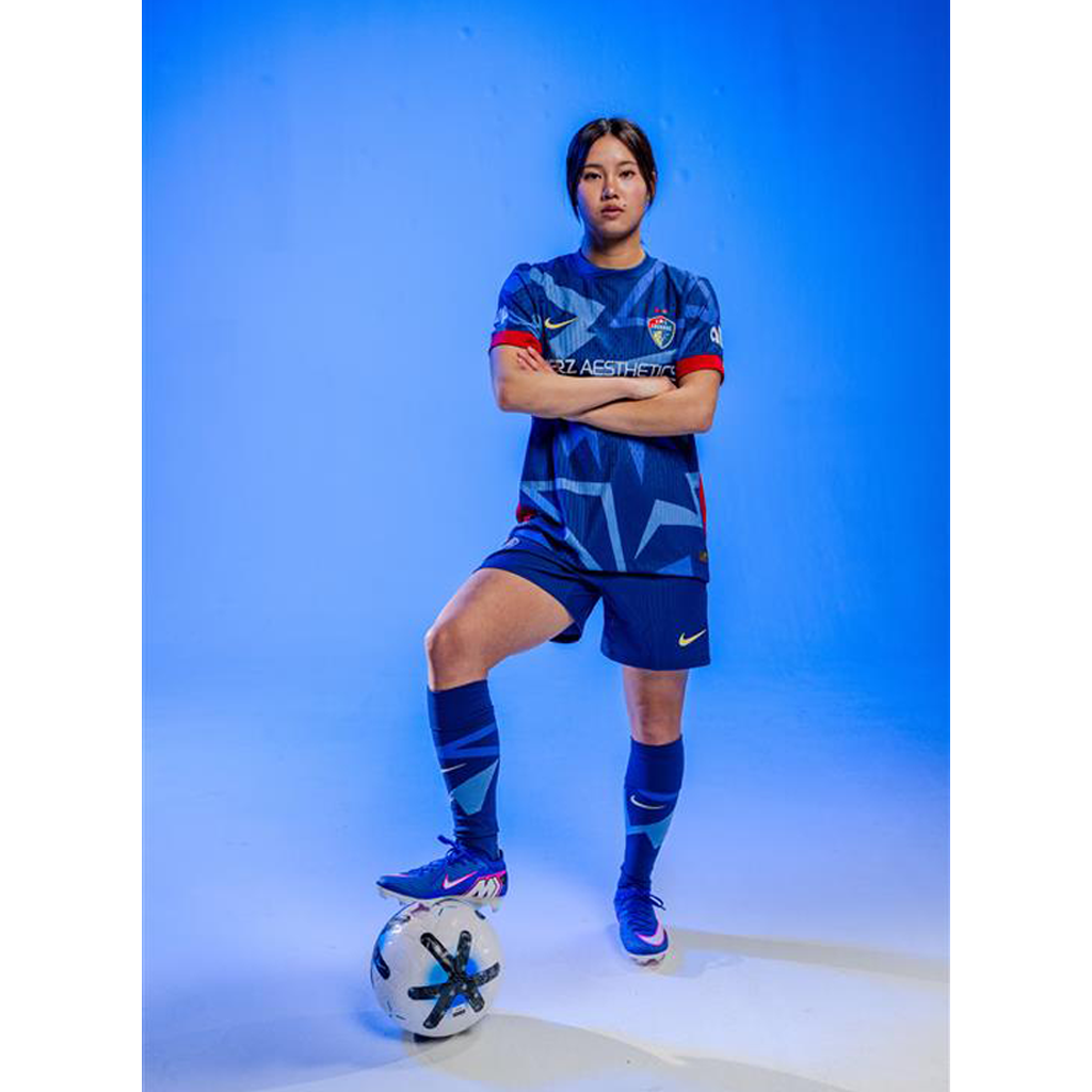 Manaka wearing 2025 Blue "The Belong" standing with the ball