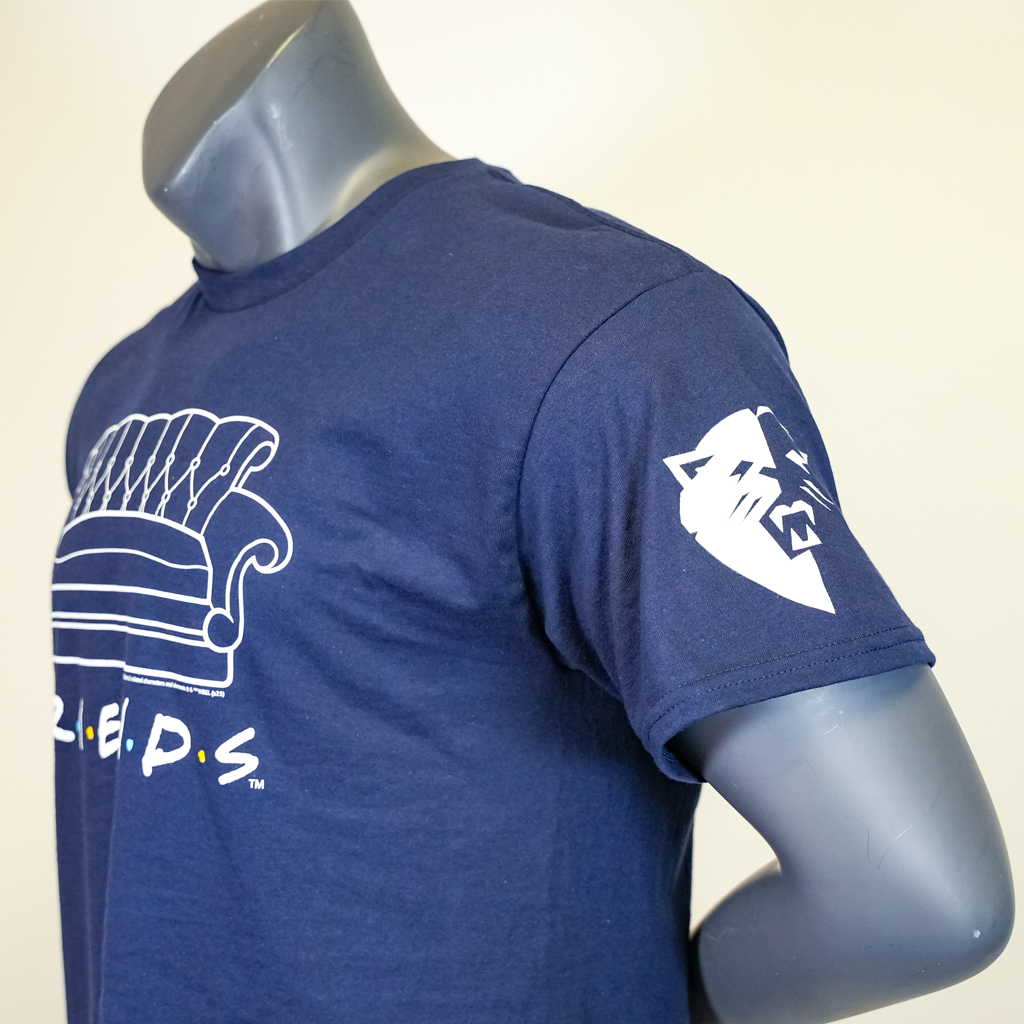 Side view of Blue T-Shirt on mannequin with Friends logo and iconic Friends couch with focus on Courage lioness on the left sleeve