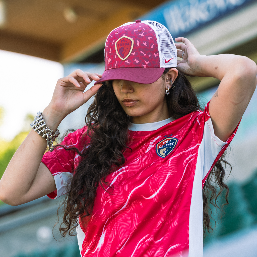 Woman wearing a pink cap with North Carolina logo and Nike logo featured.