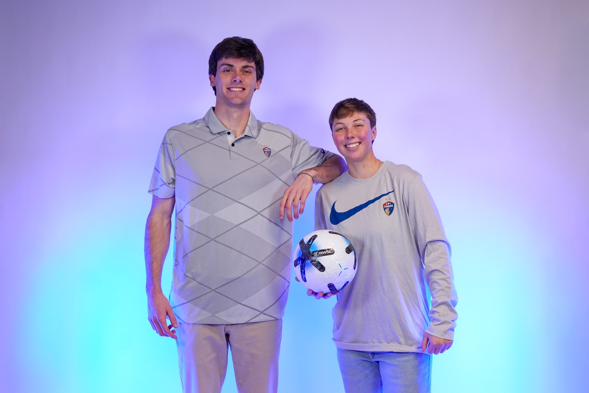 Two people wearing gray NC Courage Nike merch. 