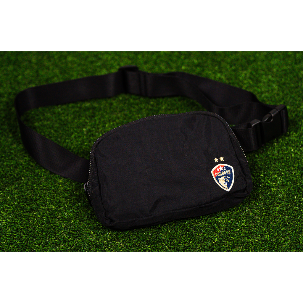 A black belt bag with the NC Courage logo placed on the front, displayed on a green background.