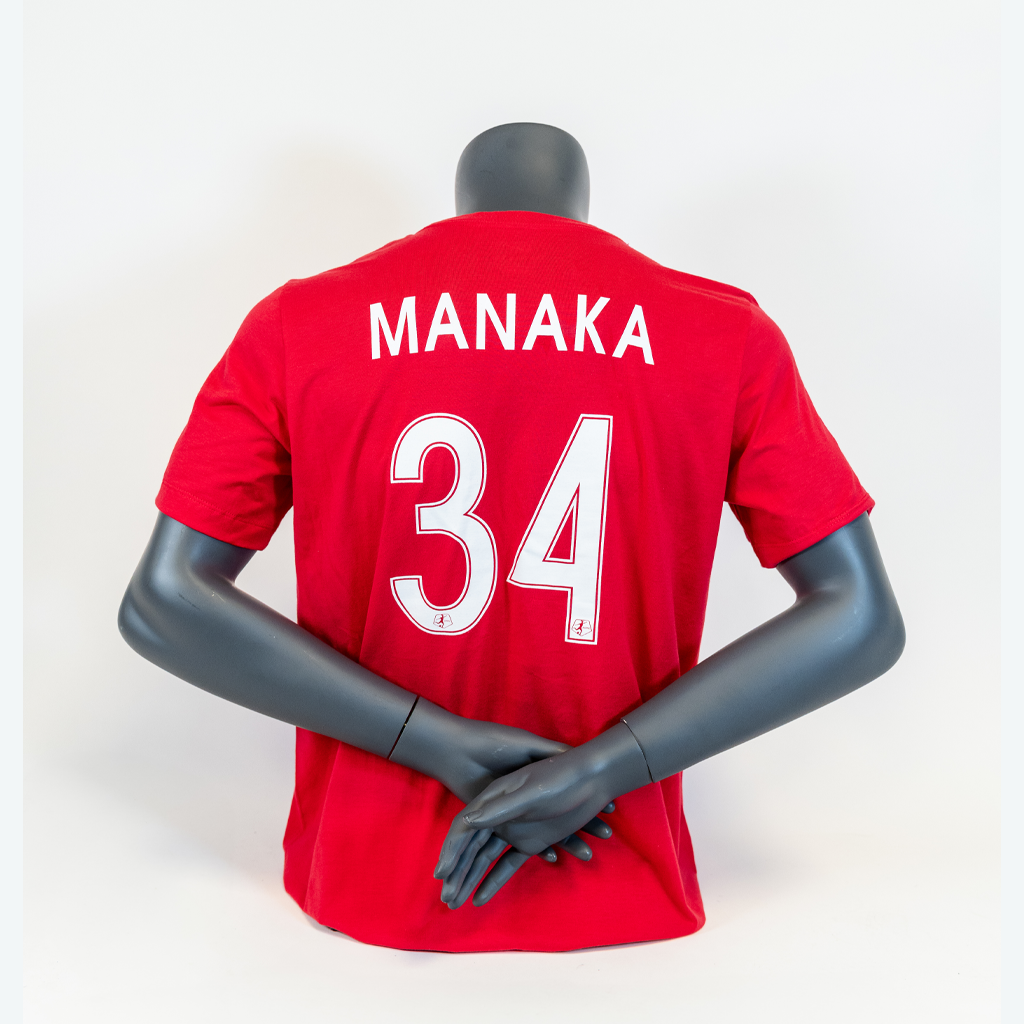 A pink soccer jersey with the name 'MANAKA' and the number '34' printed on the back, displayed on a mannequin.