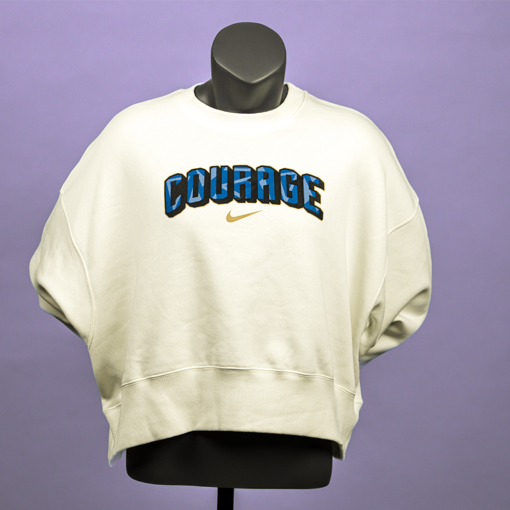 A cream cropped oversized crewneck sweatshirt with the Courage text on the front.