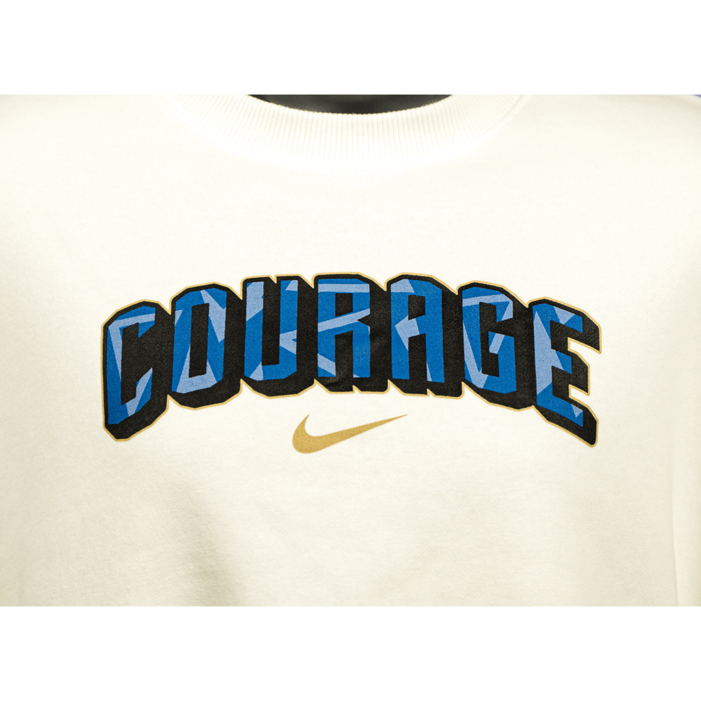 A close up of a cream cropped oversized crewneck sweatshirt with the Courage text on the front.