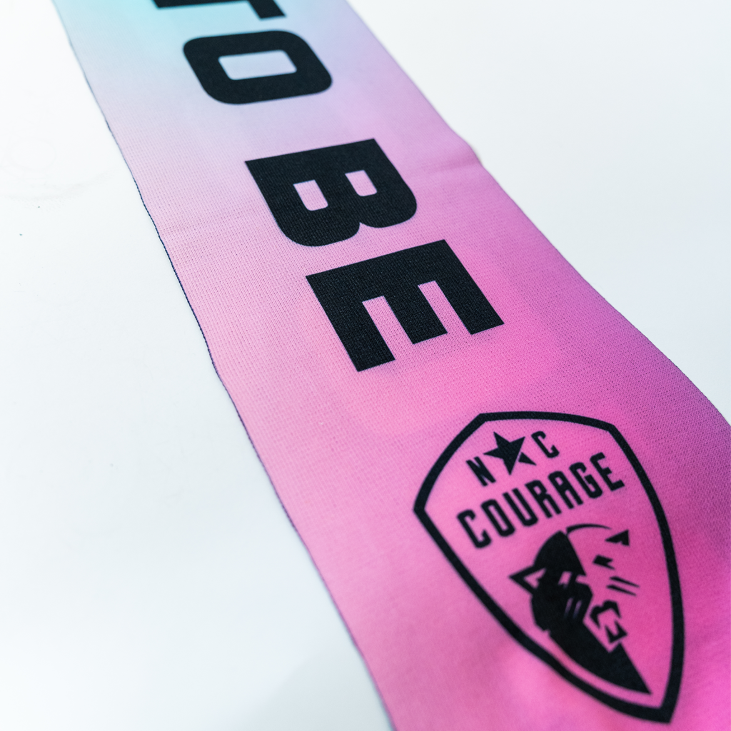 Closeup of black North Carolina Courage logo on bright pink scarf