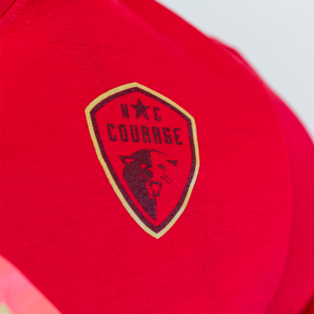 Closeup of the North Carolina Courage logo on the pink shirt