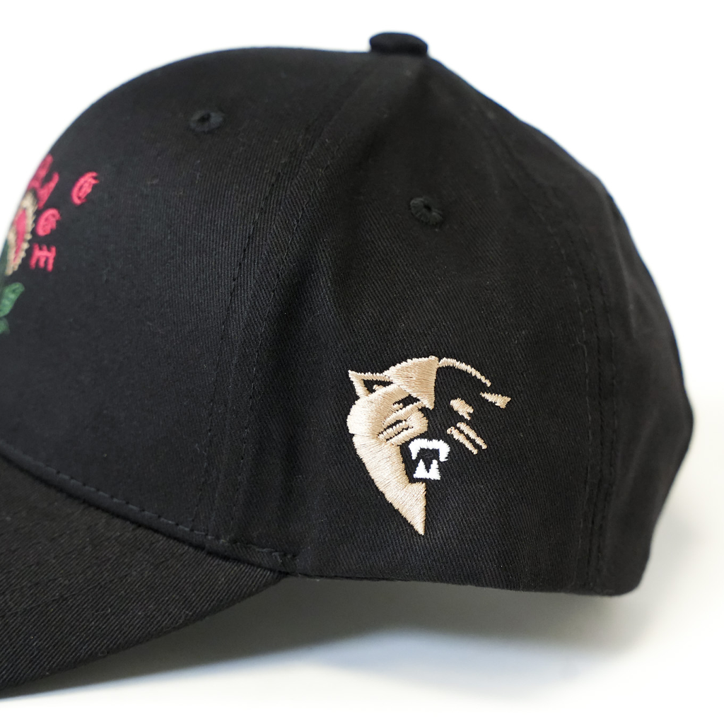 Black cap with embroidered design on a white background