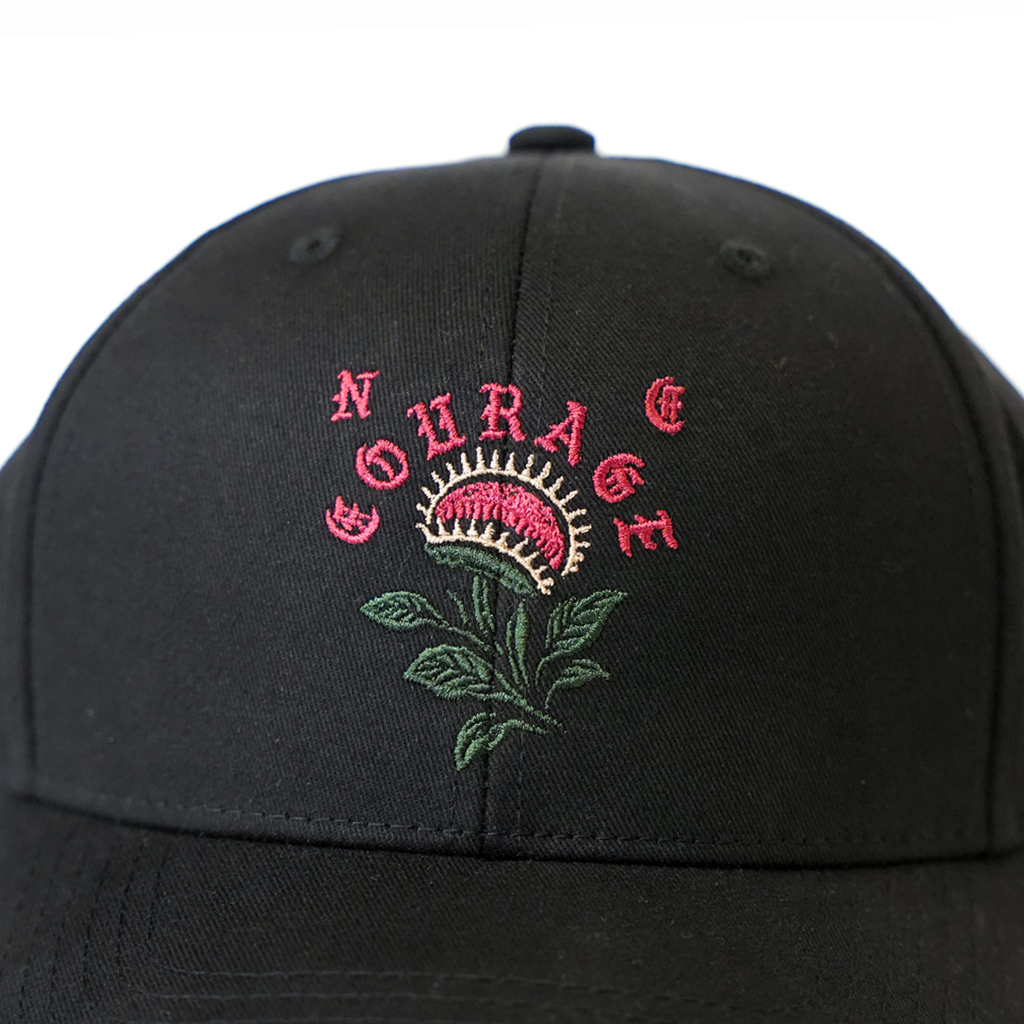 Black cap with embroidered design and text on a white background