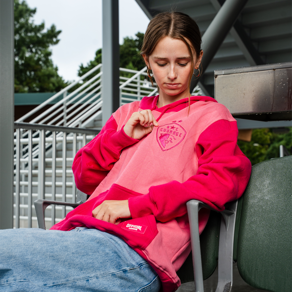 model wearing pink hoodie in a stadium
