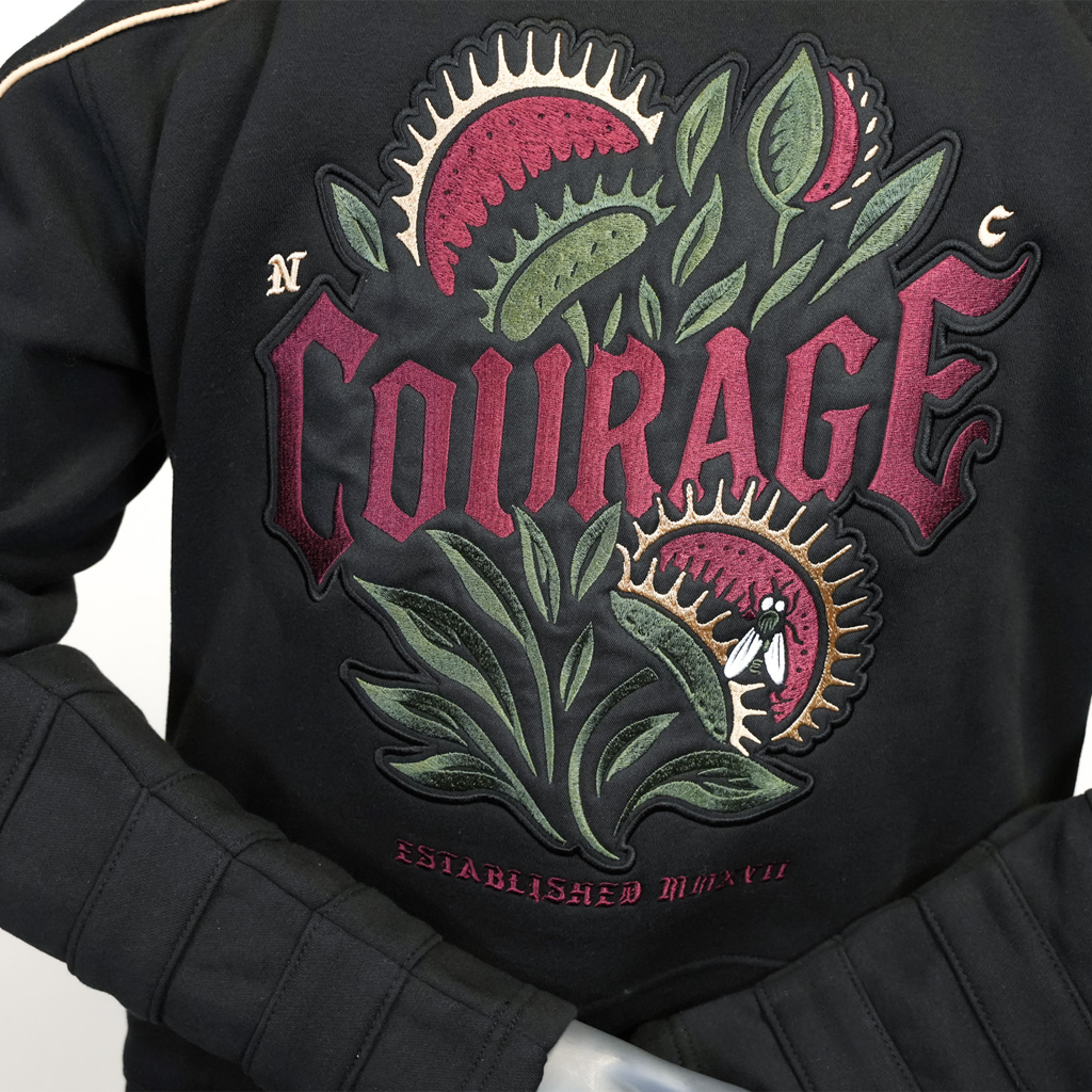 Black hoodie with 'Courage' embroidered design on a plain background