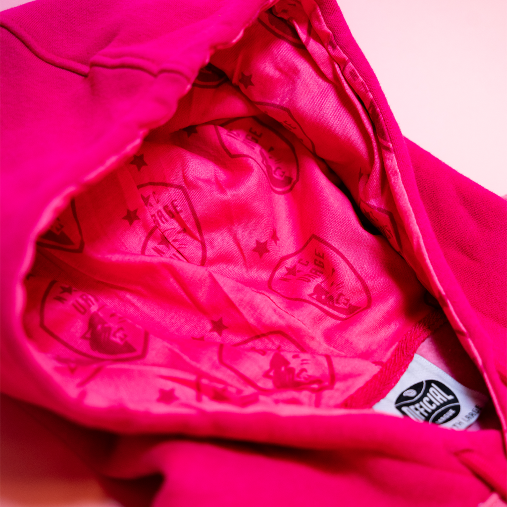 Closeup of lining in the hood that is pink with pink Courage logo  