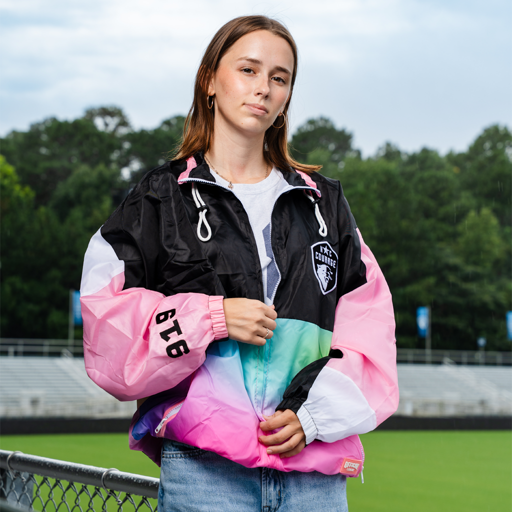 Person wearing a colorful "The Place to Be" Chute Jacket with a gradient design outdoors