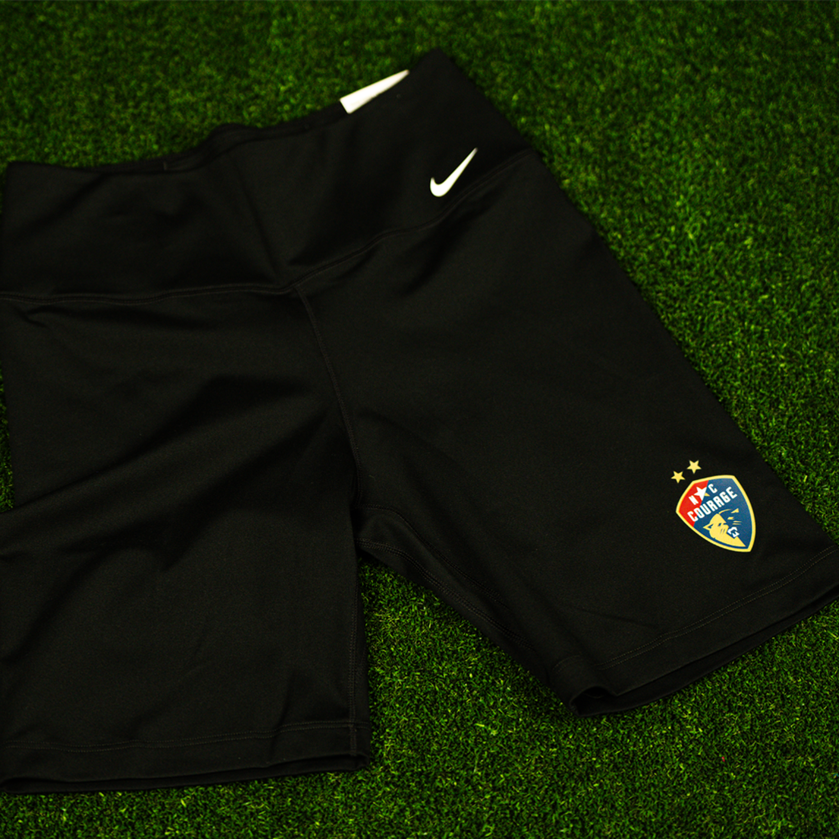 A pair of black Nike One 7" biker shorts with the NC Courage logo on the left leg.