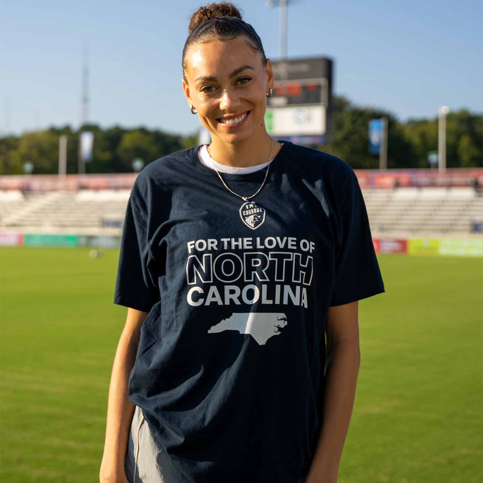 Maycee Bell models a navy blue t-shirt with the text 'FOR THE LOVE OF NORTH CAROLINA' printed on the front.