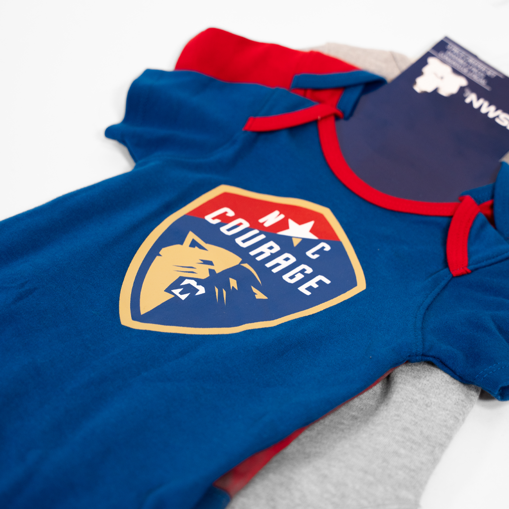 closeup of baby onesie with red trim and 'NC Courage' logo on a white background