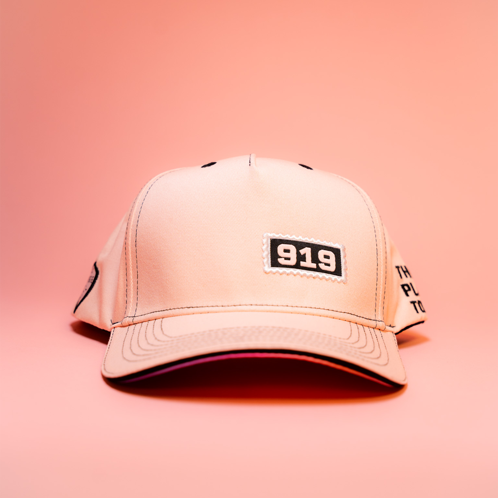 Pink cap with '919' logo on a pink background