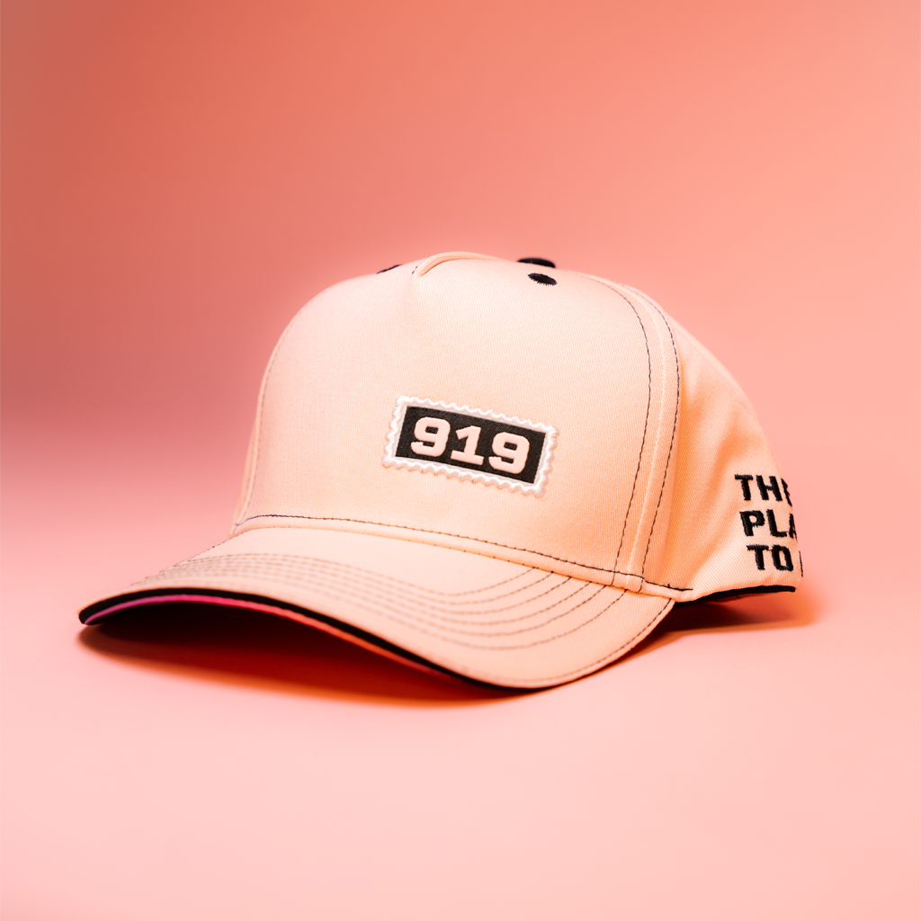 Pink cap with '919' logo on a pink background