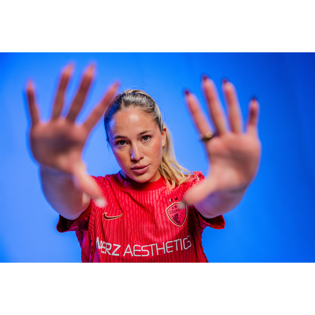 Person wearing a pink sports outfit with visible branding on a blue background