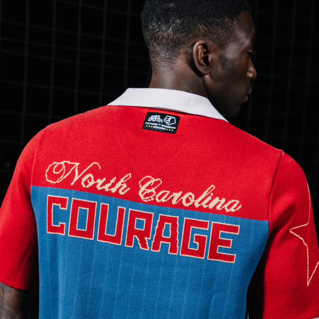 Person wearing a red and blue sports jersey with 'North Carolina Courage' text.