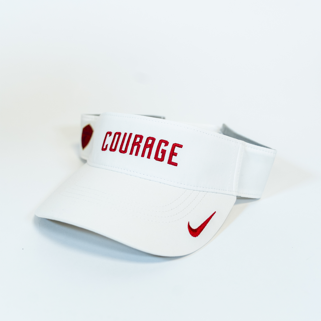 A white sports visor with the word 'COURAGE' written in red on the front panel, featuring a red Nike logo.